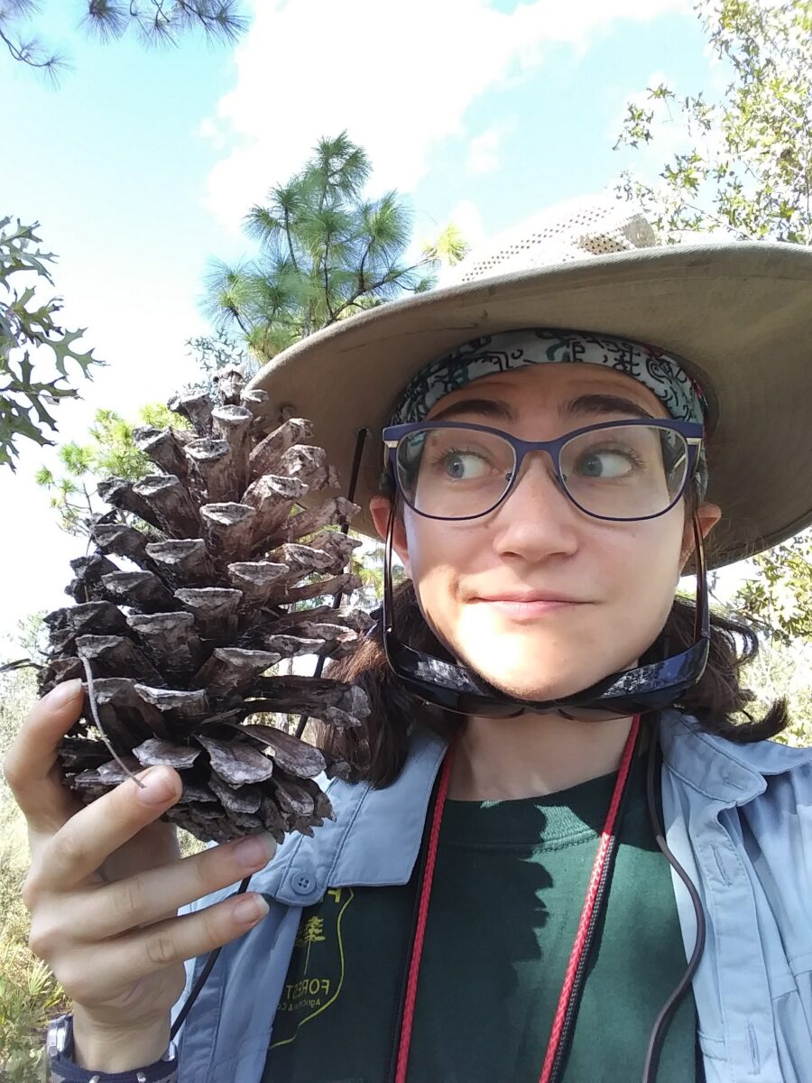 Hanna Rosner-Katz with Longleaf pinecone in Sandhill habitat